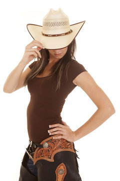 western woman brown shirt look down touch hat