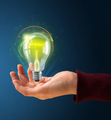 Glowing lightbulb in the hand of a woman