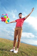 casual man creates illusion of holding balloons