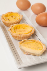 Egg tarts served in ceramic plate.