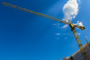 Yellow tower crane in the blue sky