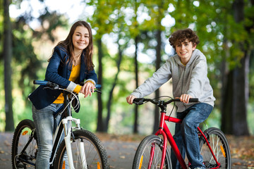 Fototapeta premium Urban biking - teens riding bikes in city park