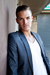 Portrait of  a beautiful young man outdoors against a wall