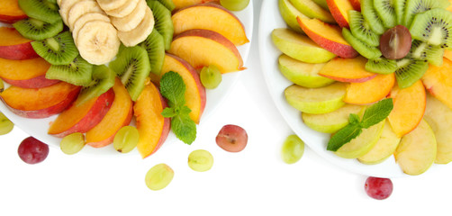 Assortment of sliced fruits on plates, isolated on white
