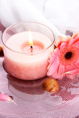 Beautiful pink candle with flower in water