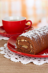 Sweet roll with cup of tea on table in kitchen
