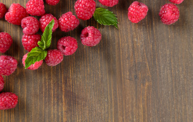 Ripe sweet raspberries on wooden background