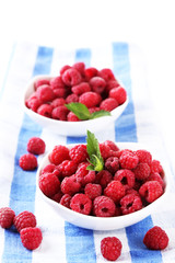 Ripe sweet raspberries in bowls, isolated on white