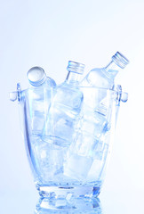 Minibar bottles in bucket with ice cubes, isolated on white