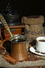 Metal turk and coffee cup on dark background
