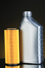 Car oil filter and motor oil can on dark color background