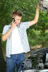 Man calling repair service after car breakdown