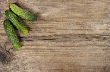 Fresh cucumber on wooden background. Rough surface, copy space