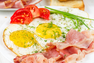 Fototapeta na wymiar Fried eggs with bacon and green onions