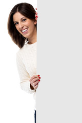 Beautiful young woman holding a blank sign
