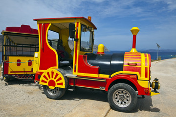 Brightly colored road train on the island of Symi, Greece.