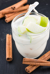 Delicious yogurt in glass with apple and cinnamon