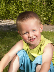 toddler is laughing on the grass in the garden