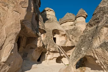 Rolgordijnen Fairy chimneys hollowed out for dwellings in Cappadocia, Turkey © dinosmichail
