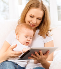 mother and baby with tablet computer on the couch at home