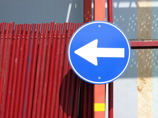 Verkehrsführung mit blauem Verkehrszeichen und weißem Pfeil im Sommer bei Sonnenschein an einer...