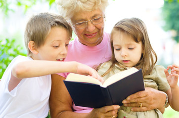 Grandmother reading  a book for grandchildren