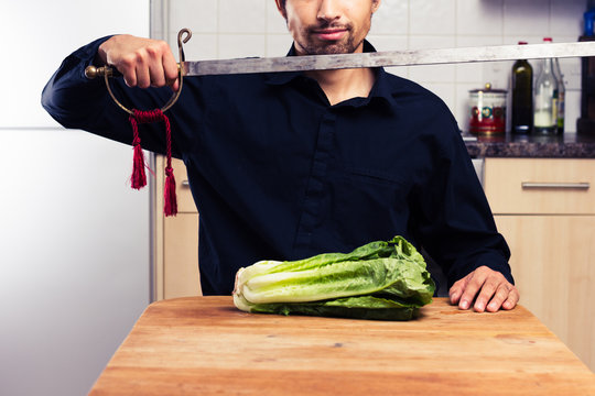 Silly man cutting lettuce with sword
