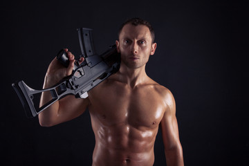 Fototapeta na wymiar Powerful young man with assault rifle