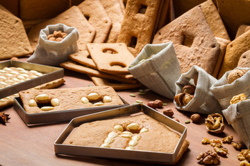 Baked gingerbread cottage elements with the ingredients for deco