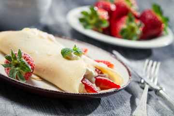 Fototapeta na wymiar Strawberry pancakes with almonds and whipped cream