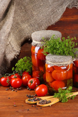 Tasty canned and fresh tomatoes on wooden table