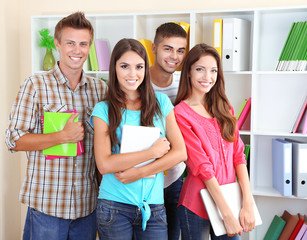 Group of happy beautiful young students at room