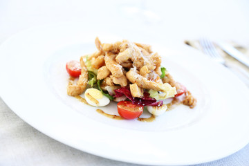 Caesar salad on white plate, close up