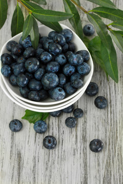 Blueberries in bowls on wooden table