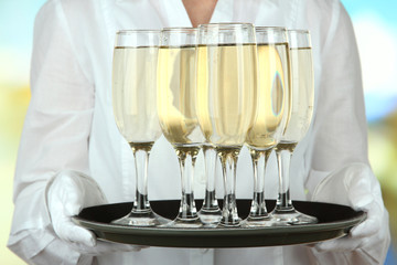 Waitresses holding tray with glasses of champagne