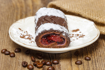Swiss roll (roulade) with raspberries on white plate.
