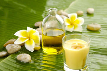Obraz na płótnie Canvas massage oil and frangipani and pile stones ,candle on leaf