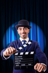 Man with movie clapper on curtain background