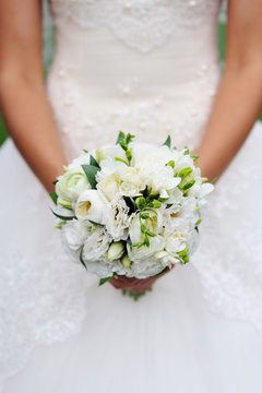 Beautiful white wedding bouquet in hand of bride