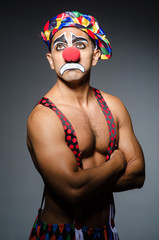 Sad clown against dark background - obrazy, fototapety, plakaty