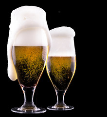 Frosty glass of light beer on black background