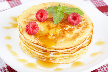 Pancakes with honey, raspberry and a mint branch