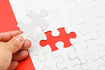 Incomplete puzzle with missing piece on human hand