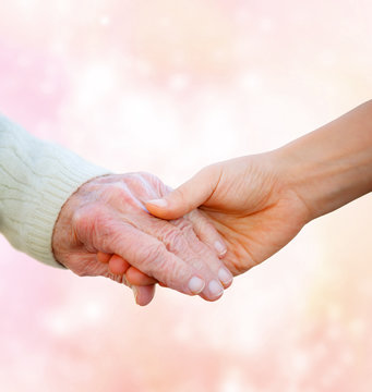Senior Lady Holding Hands with Young Woman