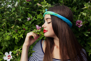 trendy teenager model with big lips smelling flowers
