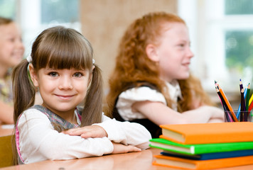 Obraz na płótnie Canvas Little girl sitting and studying at school class