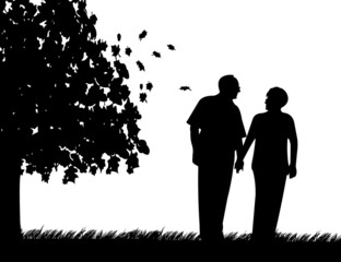 Elderly couple walking in park in autumn or fall