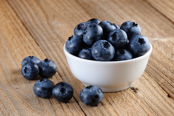 Blueberries in bowl on wooden background
