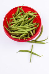 Green beans in red bowl - white background
