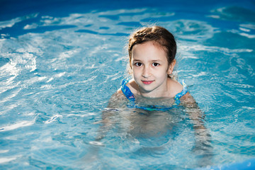 Girl swims in the pool